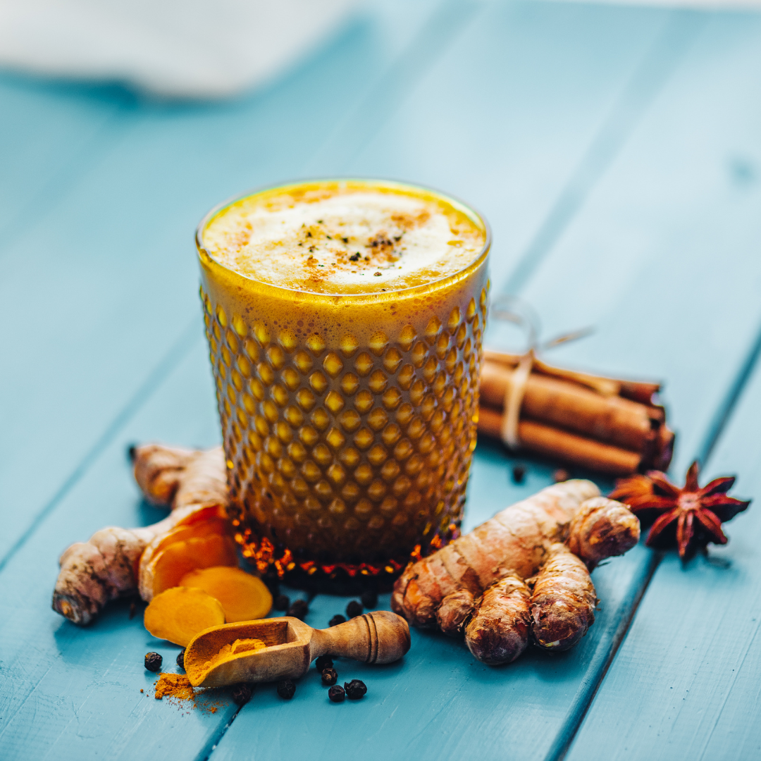 Golden milk met kurkuma, verse kurkumawortel, kaneel, steranijs en zwarte peper
